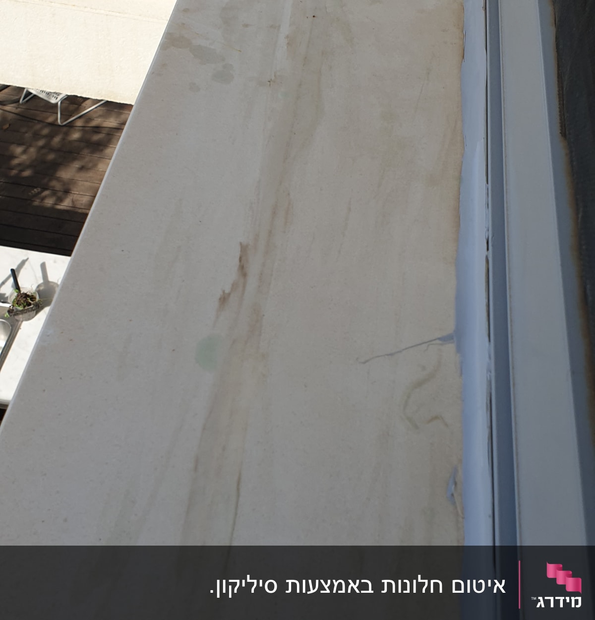 איטום חלון עם חומר לבן בפינות